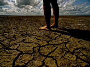 bare feet on dry, cracked soil